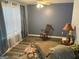 Bright sitting area with a rocking chair and patterned rug, perfect for relaxation and enjoying natural light at 565 Miles Ct, Locust Grove, GA 30248