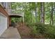 Backyard view of home featuring a covered porch, brick columns, and mature trees at 5028 Chapel Lake Cir, Douglasville, GA 30135