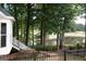 Backyard view of home with lush trees, lake views, and stone stairway at 5028 Chapel Lake Cir, Douglasville, GA 30135
