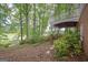 Exterior view of brick home featuring a covered porch and mature trees in the backyard at 5028 Chapel Lake Cir, Douglasville, GA 30135