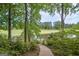 Backyard view of golf course with pond and wooded area through wrought iron fence at 5028 Chapel Lake Cir, Douglasville, GA 30135