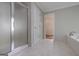 Bathroom with tile floor, a glass-enclosed shower, soaking tub, and adjacent walk in closet at 5028 Chapel Lake Cir, Douglasville, GA 30135