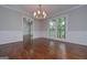 Elegant dining room with hardwood floors, wainscoting, a chandelier, and a view of the outdoors at 5028 Chapel Lake Cir, Douglasville, GA 30135