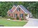 View of the side of a brick home showing mature landscaping and a drive-under garage at 5028 Chapel Lake Cir, Douglasville, GA 30135