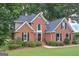 Stunning brick home featuring a large front lawn, mature landscaping, and a welcoming facade at 5028 Chapel Lake Cir, Douglasville, GA 30135