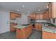 Spacious kitchen with tile flooring, wood cabinets, center island with cooktop, and stainless steel microwave at 5028 Chapel Lake Cir, Douglasville, GA 30135