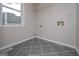 Compact laundry area with tile flooring, a window, and utility connections at 5028 Chapel Lake Cir, Douglasville, GA 30135