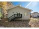 View of backyard with stairs leading to a deck, sliding glass door, and two windows on the grey siding at 7428 Mockingbird Trl, Riverdale, GA 30274