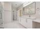 Elegant bathroom featuring double sinks, modern lighting, and a glass-enclosed shower with marble tile at 7428 Mockingbird Trl, Riverdale, GA 30274