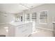 Open-concept kitchen with a large island, white cabinetry, and modern lighting, seamlessly connected to the living space at 7428 Mockingbird Trl, Riverdale, GA 30274