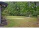 Large backyard featuring green grass, mature trees, and manicured flowerbeds at 2315 Shancey Ln, South Fulton, GA 30349