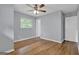 A comfy bedroom with hardwood floors, a ceiling fan, a window, and a door leading to another room at 2315 Shancey Ln, South Fulton, GA 30349