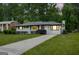 Charming white brick home with a well-maintained lawn, mature trees, and a paved driveway at dusk at 2315 Shancey Ln, South Fulton, GA 30349