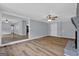 Open-concept living room boasts a fireplace, ceiling fan, and hardwood floors at 2315 Shancey Ln, South Fulton, GA 30349