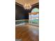 Dining room with chair rail trim, hardwood floors, a chandelier, and a large window at 2329 Lochinver Sw Ln, Conyers, GA 30094