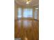 Living room with neutral walls, white trim, hardwood floors, and natural light from the windows at 2329 Lochinver Sw Ln, Conyers, GA 30094