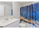Bathroom featuring a modern vanity and sink, along with a blue and gold patterned shower curtain at 3213 Blackley Old Rd, Douglasville, GA 30135