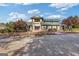 Front view of a clubhouse with stone and siding exterior, green metal roofing and beautiful landscaping at 3213 Blackley Old Rd, Douglasville, GA 30135