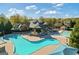 Aerial shot of a community pool featuring a large swimming area, sun umbrellas, and a spacious sun deck at 3213 Blackley Old Rd, Douglasville, GA 30135