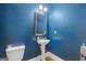 Stylish powder room with navy walls, a pedestal sink, and modern fixtures at 3213 Blackley Old Rd, Douglasville, GA 30135