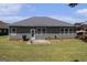 Wide backyard view shows siding, roof, patio, and lawn on a sunny day at 3634 Cape Ln, Conyers, GA 30013