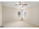 Neutral carpeted bedroom featuring a ceiling fan and two sunlit windows at 3634 Cape Ln, Conyers, GA 30013