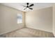 Neutral carpeted bedroom featuring a ceiling fan and one sunlit window at 3634 Cape Ln, Conyers, GA 30013