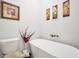 Bright bathroom showcasing a stylish standalone bathtub and tasteful decorative artwork at 3911 Peeksville Rd, Locust Grove, GA 30248
