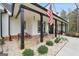 Inviting covered front porch featuring stone flooring, comfortable seating, and charming landscaping at 3911 Peeksville Rd, Locust Grove, GA 30248