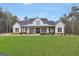 Inviting two-story modern farmhouse with black accents, a front porch, and a lush green lawn at 3911 Peeksville Rd, Locust Grove, GA 30248