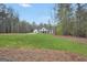 Beautiful farmhouse exterior with a long front porch, green lawn, and mature trees in a serene setting at 3911 Peeksville Rd, Locust Grove, GA 30248