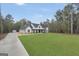 Wide exterior shot of a modern farmhouse on a large lot with green lawn and a long driveway at 3911 Peeksville Rd, Locust Grove, GA 30248