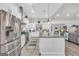 Open-concept kitchen featuring a large island, modern stainless steel appliances, and access to living area at 3911 Peeksville Rd, Locust Grove, GA 30248
