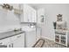 Functional laundry room with modern appliances, overhead cabinets, and a patterned floor rug at 3911 Peeksville Rd, Locust Grove, GA 30248