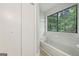 Bathroom showcasing a tub and window overlooking a green view at 5362 Kelleys Mill Cir, Stone Mountain, GA 30088