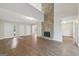 Open-concept living room with wood flooring, a stone fireplace, and access to the foyer and other rooms at 5362 Kelleys Mill Cir, Stone Mountain, GA 30088