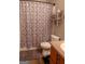 Compact bathroom featuring a patterned shower curtain, toilet, and vanity with storage at 714 Yates Rd, Bowdon, GA 30108