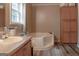 Bathroom featuring a soaking tub, vanity with sink, storage cabinet, and tile flooring at 714 Yates Rd, Bowdon, GA 30108