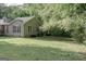 Exterior view of a house with an expansive lawn, trees, and inviting side porch at 714 Yates Rd, Bowdon, GA 30108