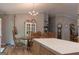Kitchen featuring an island, wooden dining set, modern chandelier, and wood floors at 714 Yates Rd, Bowdon, GA 30108