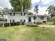 Charming two-story home with painted brick, black shutters, green lawn, and mature trees at 4049 Brookcrest Cir, Decatur, GA 30032