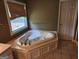 Bathroom featuring jetted tub, linen closet, tiled floor, and large window for natural light at 350 Lakeview Dr, Brooks, GA 30205