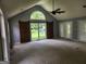 Open-concept living room with lots of light, vaulted ceiling, and barn doors to backyard at 350 Lakeview Dr, Brooks, GA 30205