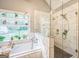 Bathroom featuring a tub, shower, and plants on a window shelf at 4333 Deer Ridge Ct, Lilburn, GA 30047