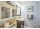 Cozy powder room featuring blue walls, vanity, and decorative cabinet at 4333 Deer Ridge Ct, Lilburn, GA 30047