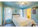 Comfortable bedroom featuring bright blue walls, natural light, and a private entry to the ensuite bathroom at 4333 Deer Ridge Ct, Lilburn, GA 30047