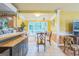 Bright dining area featuring a built-in window seat, table, and neutral tiled flooring, with a view to the kitchen bar at 4333 Deer Ridge Ct, Lilburn, GA 30047