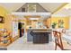 Well-lit kitchen featuring a center island, tile flooring, bright yellow walls, and an attached breakfast nook at 4333 Deer Ridge Ct, Lilburn, GA 30047