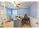 Inviting home office featuring wainscoting, a ceiling fan, hardwood floors, and large windows for natural light at 4333 Deer Ridge Ct, Lilburn, GA 30047