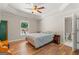 Cozy bedroom with tray ceiling, hardwood floors, a queen bed, and a bright window view at 3313 Henson Ln, Stockbridge, GA 30281
